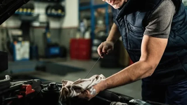 mecanico-automoviles-revisando-aceite-motor-automovil-mientras-trabaja-taller-reparacion-automoviles_637285-4299